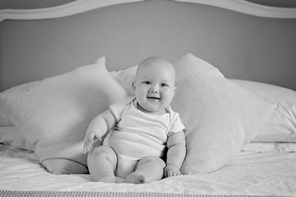 smiling 4 month baby on the bed