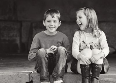 Brother and sister laughing at each other on family photoshoot