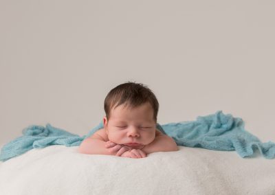 Baby boy asleep head on hands on white background for newborn photoshoot in Northampton
