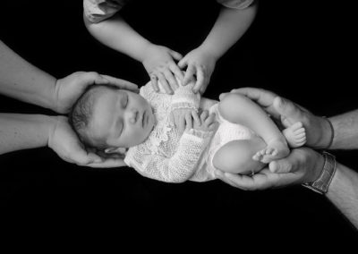 Northampton newborn photography baby girl with parents and siblings hands