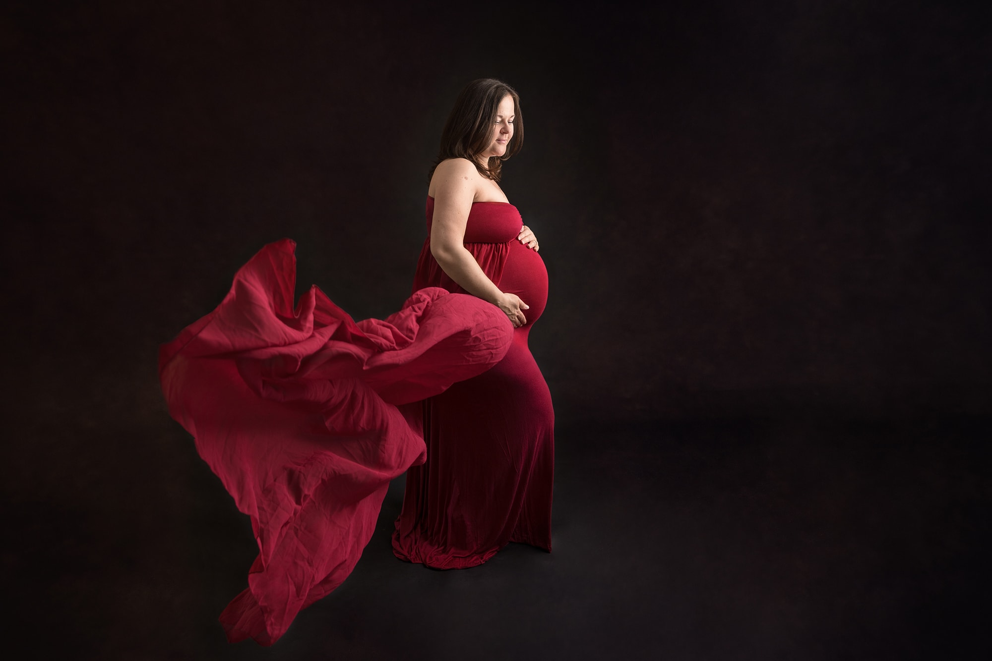 Maternity photograph of pregnant lady in red dress in Northampton
