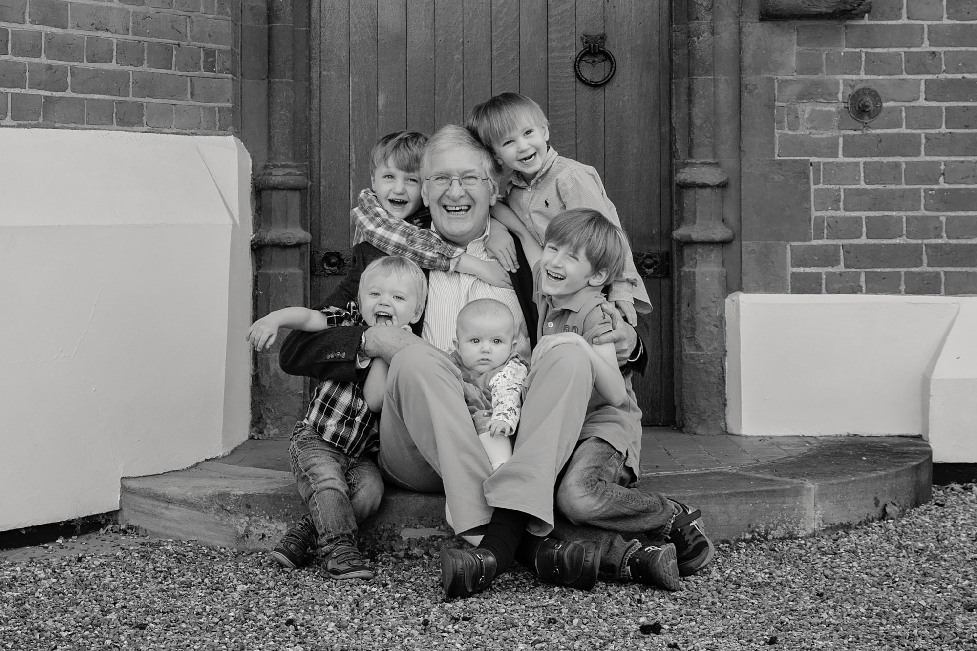 grandfather with grandchildren sitting on a doorstep in Northamptonshire